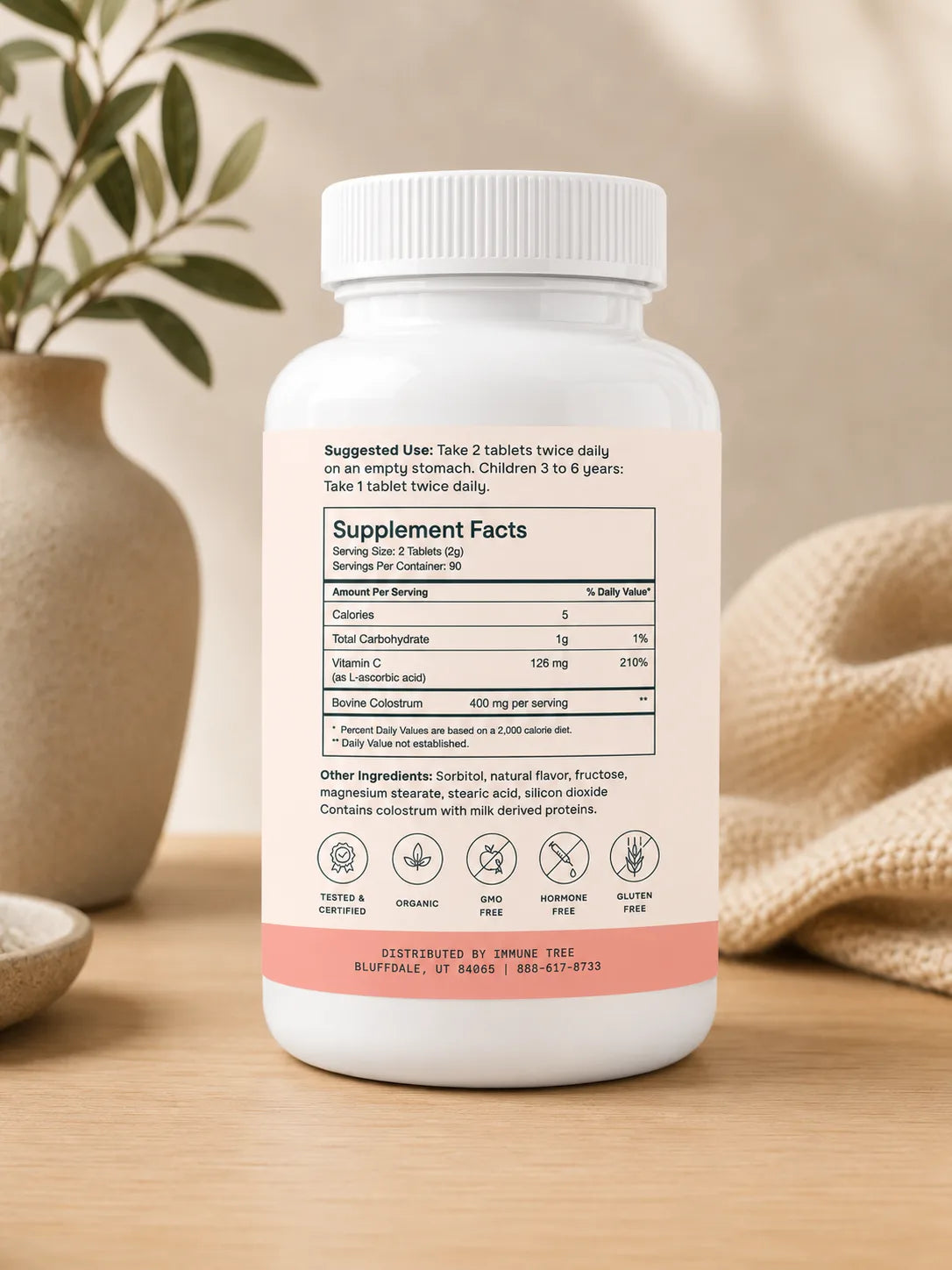 Immune Tree Colostrum6 Strawberry Moo Chews supplement bottle rear label showing Supplement Facts panel with serving size 2 tablets, 90 servings per container, 400mg bovine colostrum per serving, and 126mg Vitamin C as L-ascorbic acid at 210 percent daily value, with certifications including Tested and Certified Organic GMO Free Hormone Free and Gluten Free
