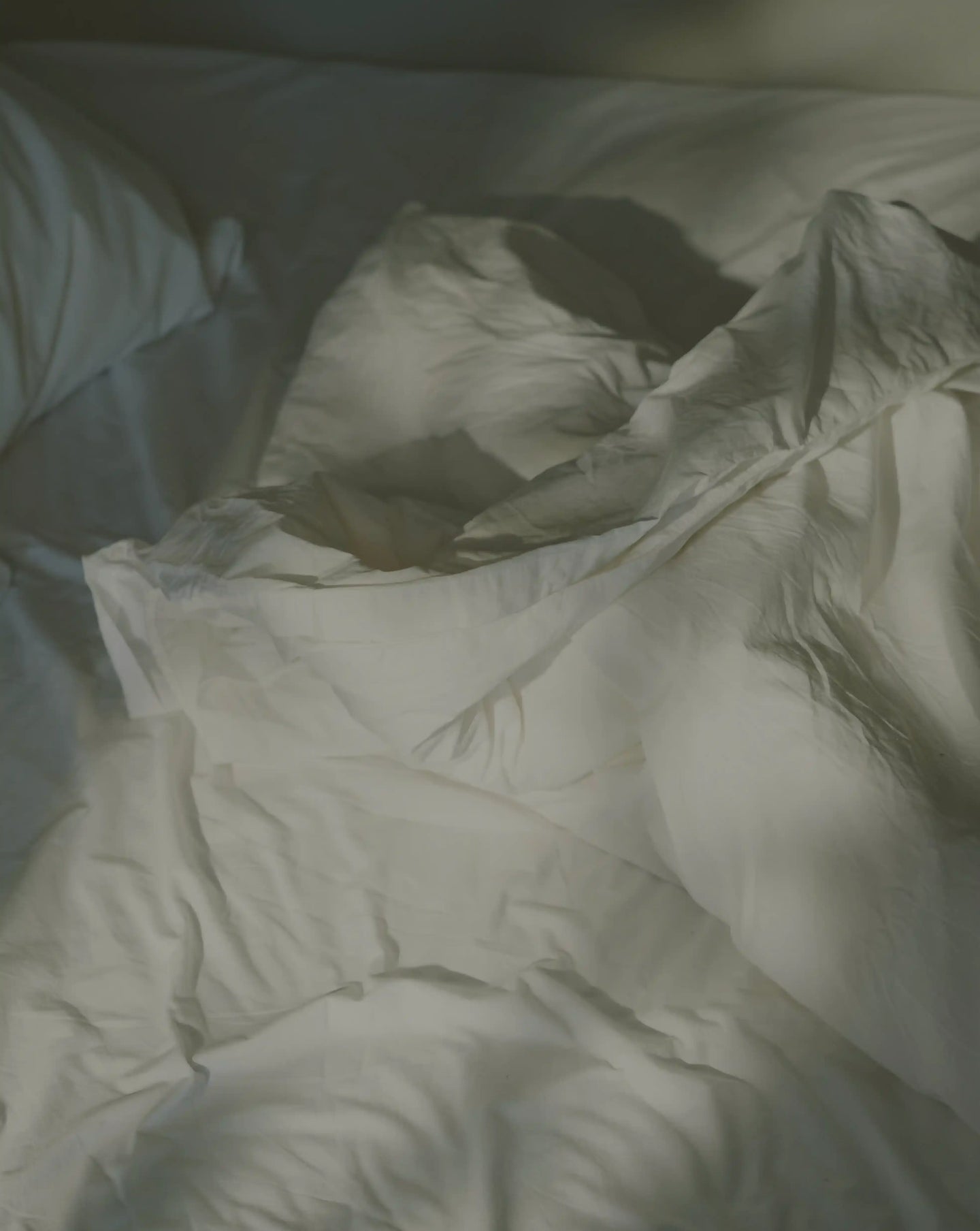 Close-up of a white comforter with folds on a bed